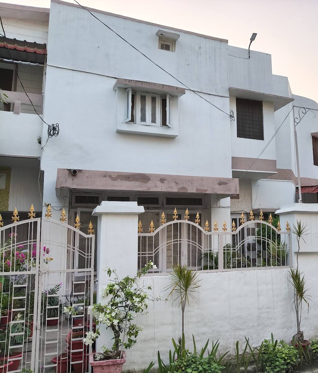 The front of the house, with a white gate and plants
