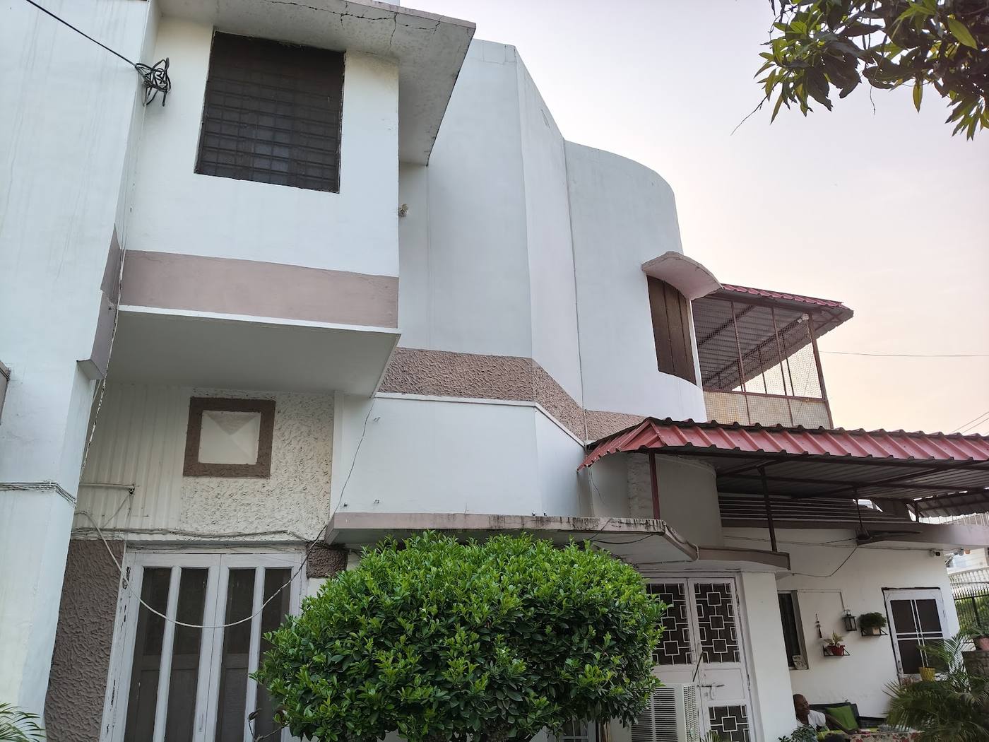 The side of the house, with balconies and trees