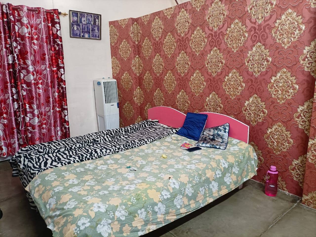 A bright room with patterned wallpaper and a cooler